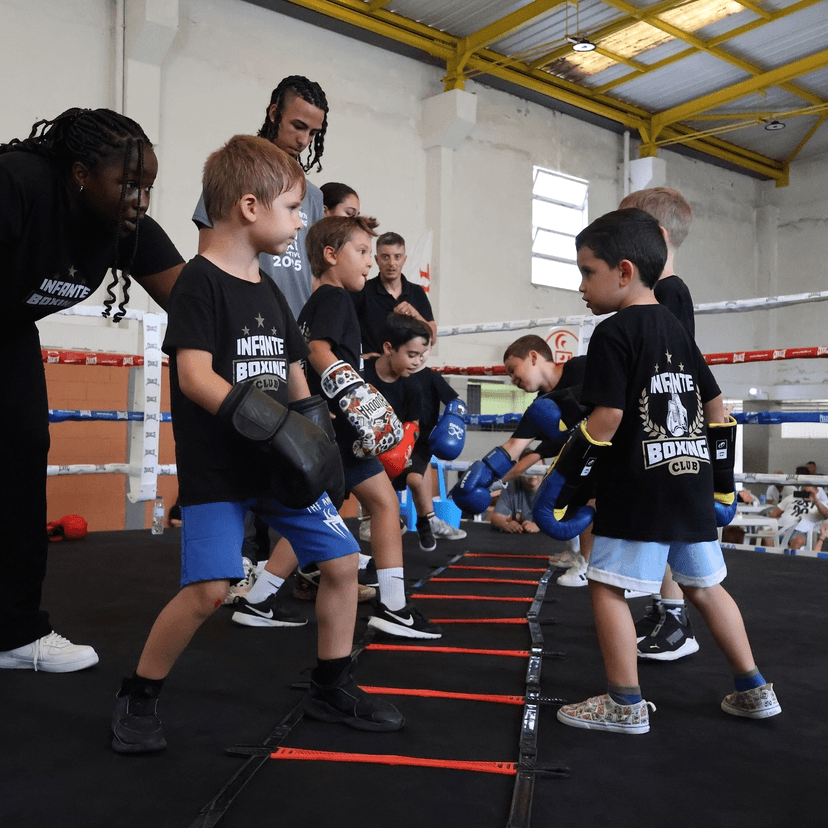 A coach teaching a young student boxing fundamentals.